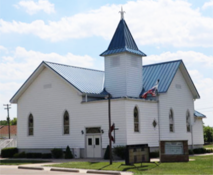 Picture of the Juddville United Methodist Church in color with stained-glass windows and short stocky steeple.